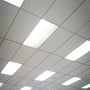 Flere V-TAC LED paneler monteret i et neddæmpet kontorloft, der giver jævn belysning.