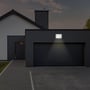V-TAC LED projektør oplyser en mørk indkørsel foran en garage om natten, viser effekt og anvendelsesområde.
