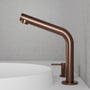 Scandtap Steel Harmonized B2 Amber håndvaskbatteri i kobberfinish med elegant, buet tud og 1-grebs betjening monteret på hvid håndvask med betonbagvæg.