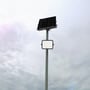V-TAC 400W LED projektør og tilhørende solpanel monteret på en høj stolpe mod en overskyet himmel.