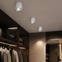 Tre hvide V-TAC LED-påbygningsspots lyser ned fra loftet i en tøjbutik.