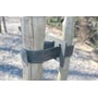 GreenMax gummiklods fastgjort mellem to træstammer med en sort gummirem og metalplader, ideel til stabilisering.