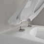 Undersiden af det løftede toiletsæde og fastgørelsesbeslagene på Villeroy & Boch Avento 5656.