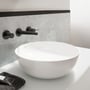 Villeroy & Boch Artis 4179 håndvask står på en bordplade under vægmonterede sorte armaturer.