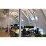 SG Armaturen Inspire 1200 LED armatur monteret i et moderne kontormiljø med skrå lofter og vinduer.
