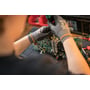 Teknikerens hænder arbejder med elektronik på værkstedet; produktet er Grundfos MAGNA3 40-60 F cirkulationspumpen.