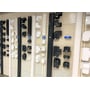 Hvid Tecnosystemi T75-kabelkanal ses blandt forskellige kabelkanaler og fittings på en udstillingsvæg.
