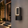V-TAC LED-væglampe i mørkt aluminium monteret ved indgangen, set tættere på med lysende ramme.