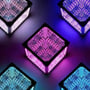 Gruppe af Infinity Cubes i forskellige farver som lilla og blå, der viser 3D RGBIC lysmønstre fra forskellige vinkler.