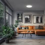 SpectrumLED Nymphea Flad Duo 24W LED loftlampe monteret i en moderne stue med orange sofa og planter.