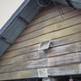 V-TAC 50W solpanel LED projektør og solpanel monteret på en træbeklædt bygning under et tag af bølgeplader.