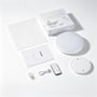 LED-loftslampen med sensor vises sammen med emballage, vejledning, fjernbetjening, kabel og monteringstilbehør.
