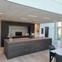 PureLED-lysskinner lyser mellem loftpladerne i et moderne køkken med mørke skabe og køkkenø.