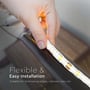 Hånd monterer V-TAC LED strip på en buet overflade, der illustrerer dens fleksibilitet og nemme installation til kantbelysning.