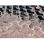 Grøn ECCOdal græsarmering nedlagt i jord og sand, der illustrerer produktets funktion og struktur.