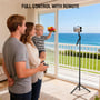 En familie styrer 4smarts 360° AI-stativ med fjernbetjening, mens en mobil filmer fra tripoden.