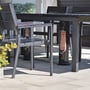 Mensa Heating terrassevarmer IMUS 550W i sort, placeret under et havebord med stole, lyser op med infrarøde varmestråler.