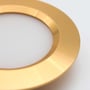 Neutral Reco68 møbelspot i guld med hvid lysflade og tætliggende riller i den runde kant.