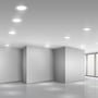 Flere V-TAC LED-indbygningspaneler lyser i et lyst, moderne rum med hvide vægge og loft.