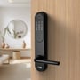 Sort Zafe T-Lock oval lås monteret på en trædør med numerisk tastatur og dørgreb i en lys bolig.