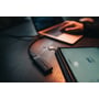 Verbatim Keypad Secure USB-drev ligger på et mørkt skrivebord ved siden af en tablet og en bærbar computer.