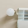 Shelly BLU TRV Gen3 radiatortermostat sidder på en radiator, set lige forfra med et nul på displayet.
