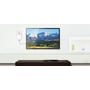 TP-Link TL-PA8010P powerline-adapter i stikkontakten ved siden af et tv, der viser et bjerglandskab.