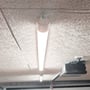 LEDlife slimarmatur lyser under loftet med kablet tilsluttet ved enden af det hvide armatur.