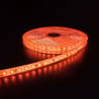 Detaljeret billede af orange LED strip på en rulle med mørk baggrund, der viser de enkelte LED'er.