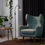 Sort Twist gulvlampe fra Nielsen Light placeret i et hyggeligt hjørne ved siden af en mintgrøn lænestol og et sidebord.