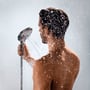 Mand tager brusebad med Hansgrohe Raindance Select E120 Eco bruser med vandstråler omkring sig.