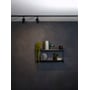 Astro Lighting Ascoli 1-faset skinnespot i mat sort monteret på en loftsskinne over en reol.