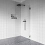 Contura Shower brusevæg monteret i et moderne badeværelse med hvide fliser og grå terrazzo gulv.