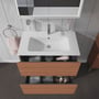 Duravit L-Cube vaskeskab med to skuffer i trælook, viser vask, armatur og åbne skuffer med tilbehør som håndklæder og hårtørrer.