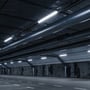 SpectrumLED LIMEA GO hermetisk LED-armatur installeret i en parkeringskælder med rør og ventilationssystemer.