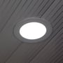 Det runde V-TAC LED panel er installeret i et mørkt loft med striber, og lyset er tændt med kold hvid farve.