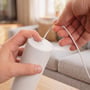 Hænder håndterer ledningen ved den hvide dæmpbare spisebordslampe, som hænger på wireophæng.