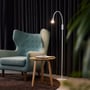 Twist gulvlampe placeret i et hyggeligt hjørne ved en lænestol og et lille bord, med dæmpet belysning.