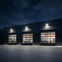 V-TAC LED-projektør på 150 W lyser op over portene på en lagerbygning om aftenen.