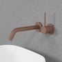 Scandtap Harmonized 1 indbygningsvandhane i rustfrit stål med kobberfinish, monteret på betonvæg over hvid håndvask.