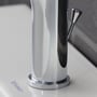 Nærbillede af Duravit A.1 håndvaskarmatur, der viser den blanke krom finish og den cylindriske base på en hvid vask.
