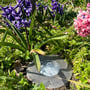 Light By Juul Gold nedgravningsspot monteret i et blomsterbed mellem hyacinter, med linserne synlige i fronten.